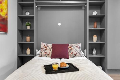 una bandeja de comida en una cama con dos vasos de zumo de naranja en B20 Apartments, en Reikiavik