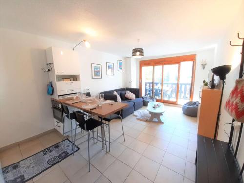 eine Küche und ein Wohnzimmer mit einem Tisch und einer Couch in der Unterkunft Studio 4 pers - Saint Lary Soulan, WiFi, proche pistes - FR-1-457-298 in Saint-Lary-Soulan
