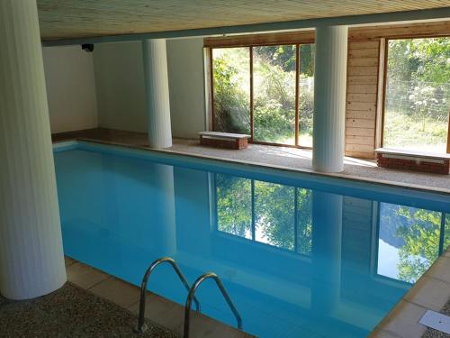 - une grande piscine bleue dans une maison dotée de fenêtres dans l'établissement Studio 28m² au centre avec piscine et balcon ! - FR-1-573-44, à Saint-Jean-dʼAulps