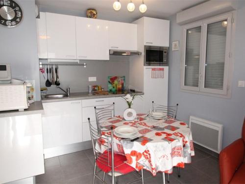 une cuisine avec une table et des chaises dans une pièce dans l'établissement Charmant T2 à Luchon - 46m², Balcon Sud-Est, proche thermes, idéal 4 pers, tout confort. - FR-1-313-174, à Luchon
