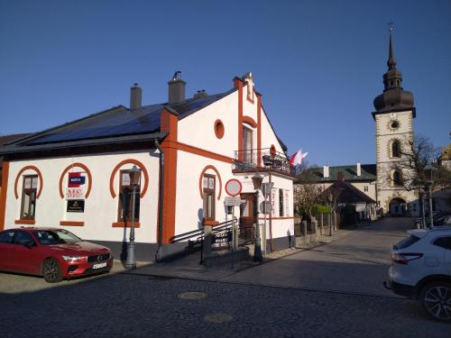 a white and orange building with a clock tower at Noclegi U Bram Klasztoru in Stary Sącz
