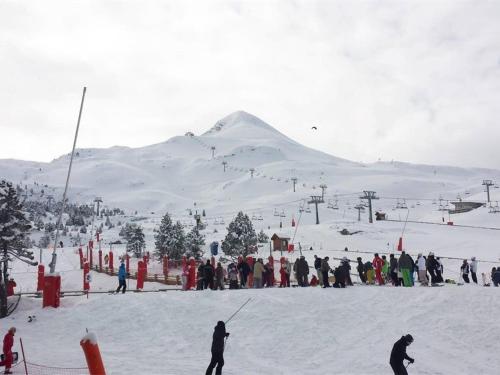 un grupo de personas de pie en una pista de esquí cubierta de nieve en Studio cosy pour 4 avec balcon et Wi-Fi, accès direct aux pistes - FR-1-602-59, en Arette
