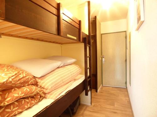 Cette petite chambre comprend 2 lits superposés et une porte. dans l'établissement Studio cosy 4 pers. accès direct pistes à Arette - FR-1-602-45, à Arette