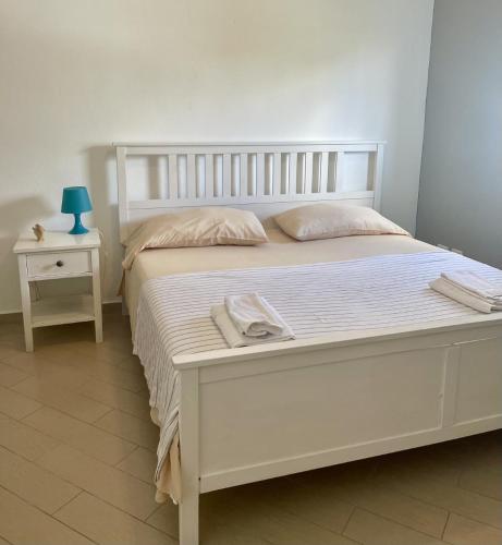 a white bed in a bedroom with a blue lamp on a table at B&B Villa Luna in Bayahibe