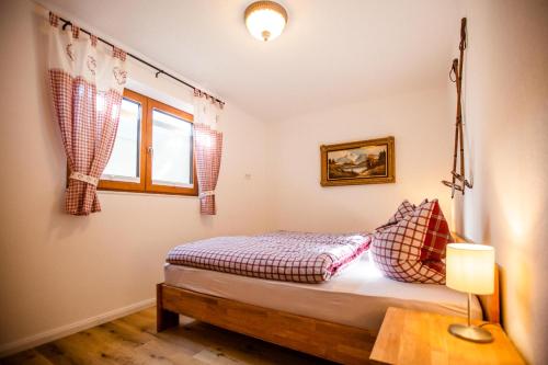 um quarto com uma cama com um candeeiro e uma janela em Apartment Almglück em Ehrwald