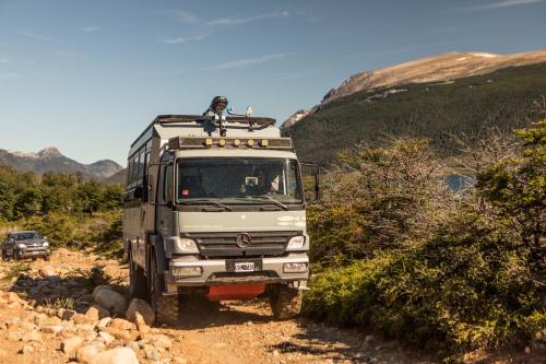 a white truck driving down a dirt road at Lago Rosario Lodge in Trevelin