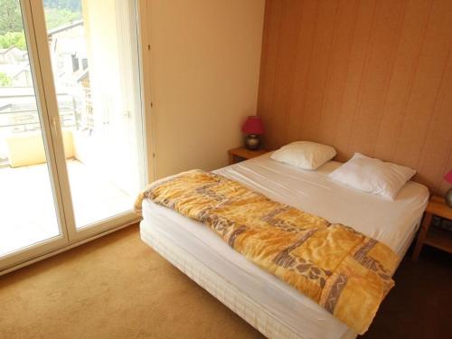 ein Schlafzimmer mit einem Bett und einem großen Fenster in der Unterkunft Appartement Bagnères-de-Luchon, 4 pièces, 6 personnes - FR-1-313-140 in Luchon