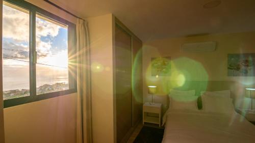 カリェタにあるMadeira Inn Refugio do Solのベッドルーム1室(ベッド1台、大きな窓付)
