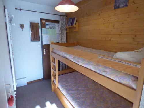 a bedroom with two bunk beds in a wooden wall at Studio Saint-Jean-de-Sixt, 1 pièce, 4 personnes - FR-1-458-152 in Saint-Jean-de-Sixt
