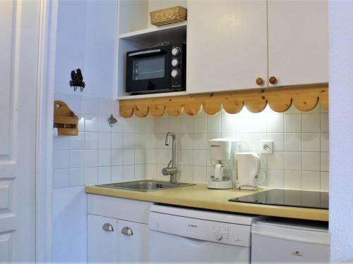 une cuisine avec un évier et un micro-ondes dans l'établissement Studio cabine 6 pers à Risoul 1850, skis aux pieds, balcon sud, proche navette gratuite - FR-1-330-544, à Risoul