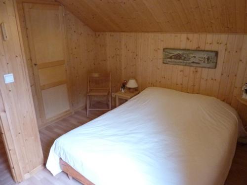 een slaapkamer met een wit bed in een houten kamer bij Chalet Le Biot, 6 pièces, 8 personnes - FR-1-573-52 in Le Biot