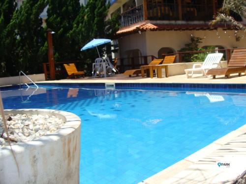uma grande piscina azul com cadeiras e um guarda-sol em São Roque Park Hotel em São Roque