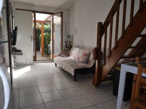 un salon avec un canapé et un escalier dans l'établissement Charmant Pavillon pour 6, Piscine et Parking Privé, à 300m de la Plage - Argelès-sur-Mer - FR-1-388-191, à Argelès-sur-Mer