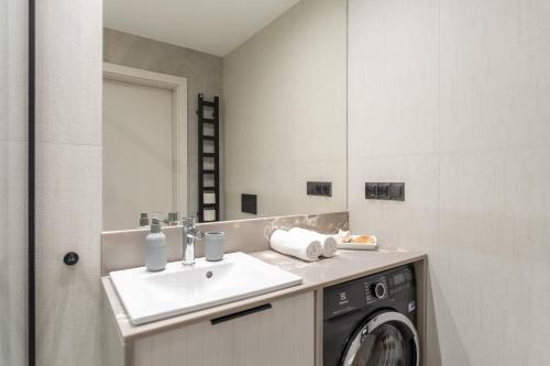 a bathroom with a sink and a washing machine at MARE SHELLTER ROGOWO koło Kołobrzegu in Rogowo