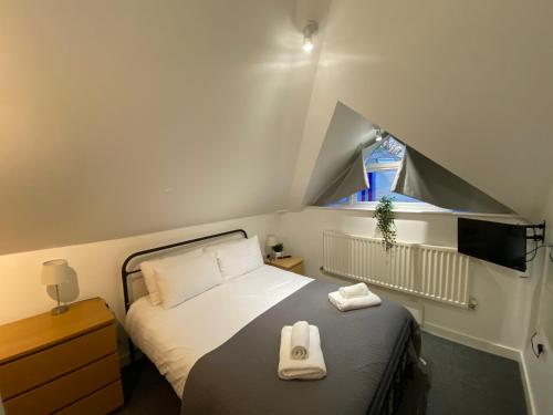 um quarto com uma cama com duas toalhas em School Path Ironbridge Home with Rear Garden em Telford