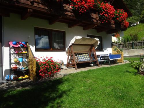 uma casa com um gazebo e flores num quintal em Haus Hackl em Jerzens