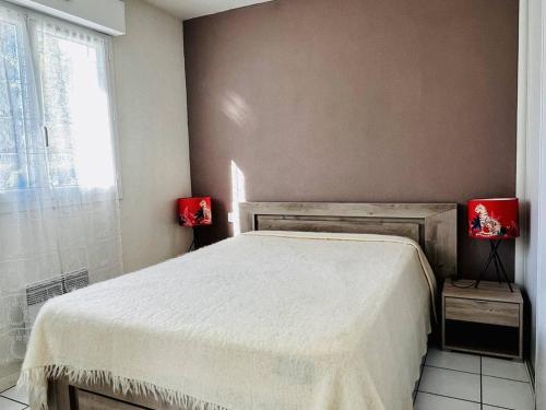 1 dormitorio con 1 cama y 2 lámparas rojas en las mesas en Appartement Cambo-les-Bains, 2 pièces, 2 personnes - FR-1-495-102, en Cambo-les-Bains
