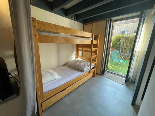 Ce lit superposé se trouve dans un dortoir doté d'une grande fenêtre. dans l'établissement Villa 2 pièces mezzanine, 6 couchages, piscine, 900m de la plage, Saint-Cyprien - FR-1-225D-126, à Saint-Cyprien
