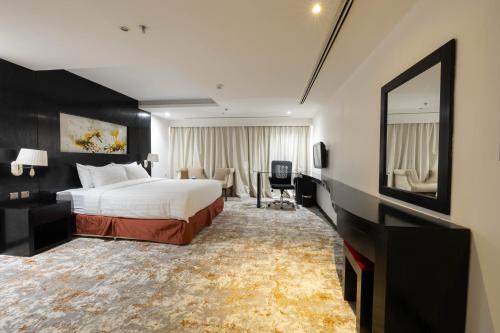 a hotel room with a bed and a mirror at Mira Business Hotel in Riyadh