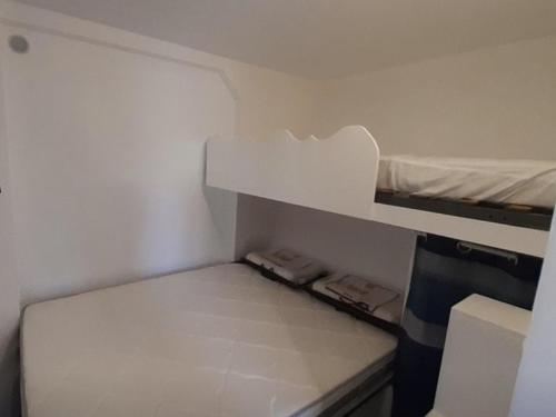 Cette petite chambre blanche comprend des lits superposés. dans l'établissement Charmant T2 proche océan avec terrasse, wifi et parking privé - Vieux-Boucau, 4/5 pers. - FR-1-379-132, à Vieux-Boucau-les-Bains