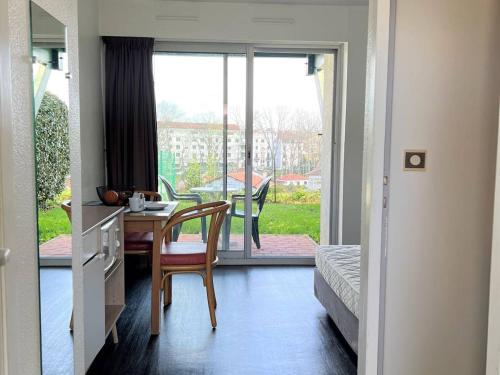 une chambre avec une table et une chambre avec un balcon dans l'établissement Studio cosy avec terrasse, parking, Internet - 2 pers., proche thermes et centre - Animaux admis - FR-1-495-100, à Cambo-les-Bains