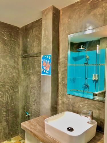 a bathroom with a sink and a shower and a mirror at Pana Long Beach Resort - SHA Plus in Ko Lanta