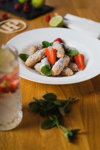 a plate of food with strawberries on a table at Hotel Palatín in Oravský Podzámok
