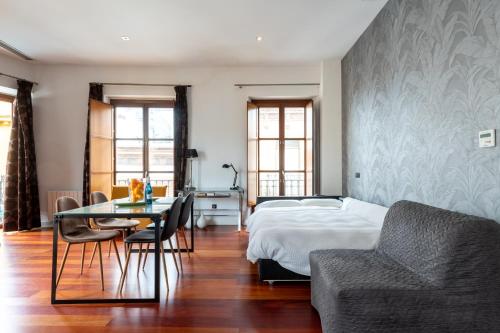 ein Schlafzimmer mit einem Bett, einem Tisch und einem Sofa in der Unterkunft Cathedral Apartment, upper floor apartment in Sevilla