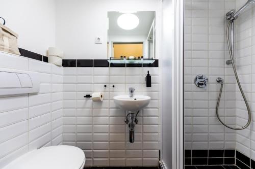 a white bathroom with a sink and a toilet at Adagio Downtown Rooms in Budapest
