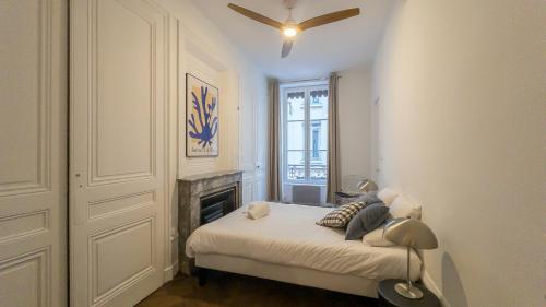 1 dormitorio con 1 cama con chimenea y ventilador de techo en NOCNOC - Le Rayonnant en Lyon