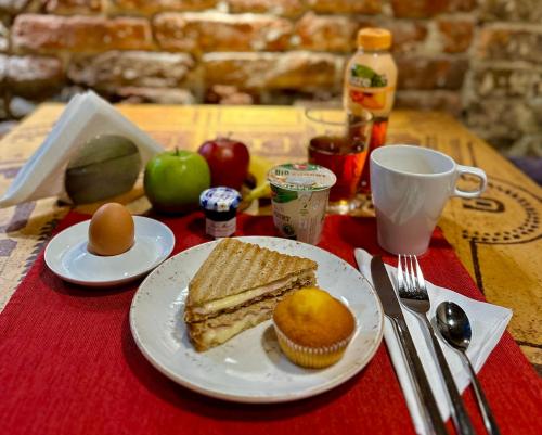 a table with a plate with a sandwich and a cupcake at Design Hotel 36 in Sofia