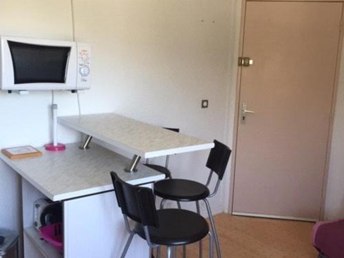 une cuisine avec une table et des chaises et un micro-ondes dans l'établissement Studio cosy, au pied des pistes à La Pierre St Martin, parking gratuit, ascenseur, casier à skis - FR-1-602-86, à Arette