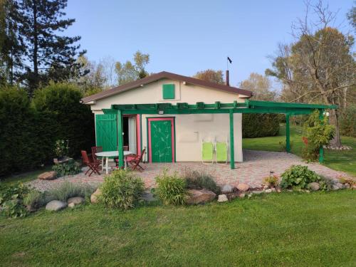 ein kleines Haus mit einer grünen Tür und einer Terrasse in der Unterkunft Chata nad Wisłą u Macieja in Dobrzyków