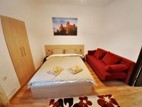 una camera da letto con un letto e un divano rosso di Smile Studio a Braşov