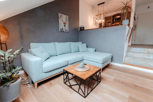 a living room with a blue couch and a table at CozyStay - Gemütliche Wohnung im Oberharz in Sankt Andreasberg