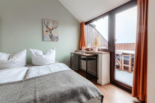 1 dormitorio con cama y ventana grande en CozyStay - Gemütliche Wohnung im Oberharz, en Sankt Andreasberg