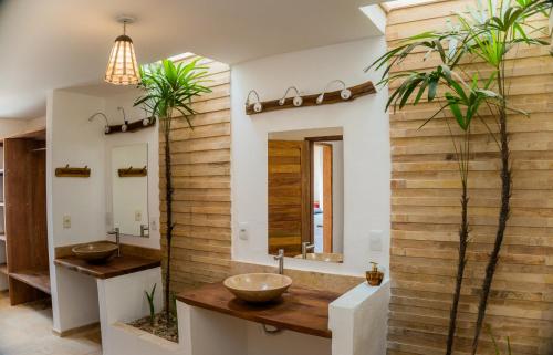 La salle de bains est pourvue de 2 lavabos et d'un mur en bois. dans l'établissement Jehol Jericoacoara, à Jericoacoara