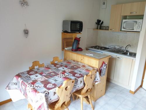 une petite cuisine avec une table et une table et des chaises dans l'établissement Studio cosy avec balcon, parking et départ skis aux pieds à Saint-Jean-d'Aulps - FR-1-573-48, à Saint-Jean-dʼAulps
