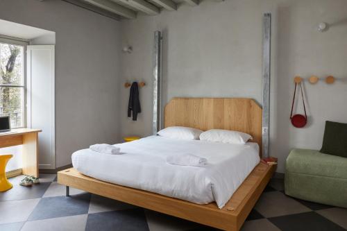 ein Schlafzimmer mit einem Bett mit weißer Bettwäsche und einem Sofa in der Unterkunft Combo Milano in Mailand