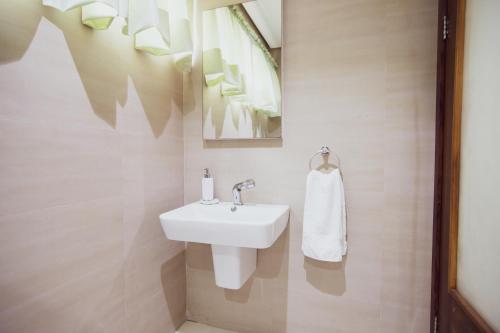 a bathroom with a white sink and a mirror at Rushmore - Premier 1 Room in Lagos