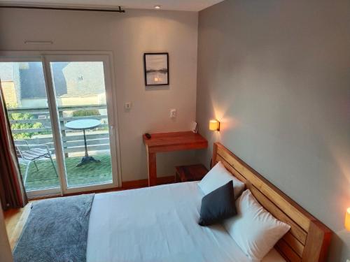 a bedroom with a bed and a large window at Hotel Au Bout Du Monde in Le Conquet