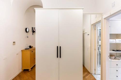 a large white cabinet in a room with a hallway at Vittoria Charme in Rome
