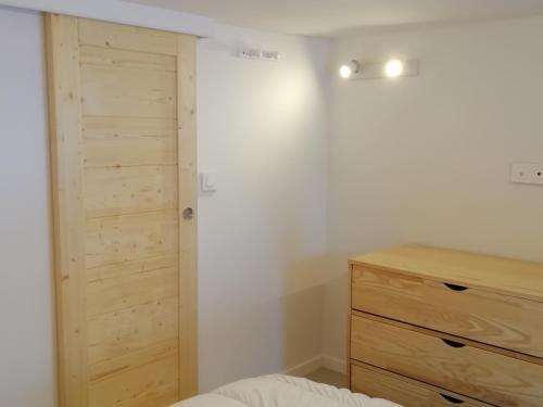 - une chambre avec un placard en bois et une commode dans l'établissement Duplex 2 pièces - 5 pers, balcon au sud, skis aux pieds, à 3 min du Transarc, village Charmettoger - FR-1-411-831, à Bourg-Saint-Maurice