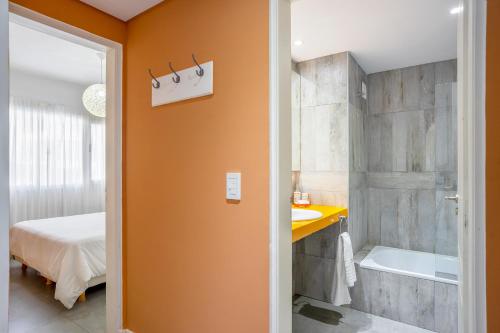 een badkamer met een douche, een bad en een wastafel bij Departamento Apart Espacio Marina in Villa Gesell