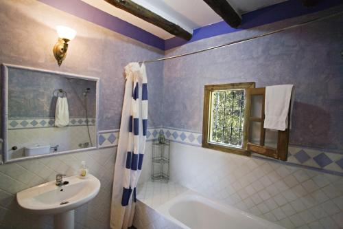a blue and white bathroom with a sink and a tub at Villa La Clavelina Rocabella in El Chorro
