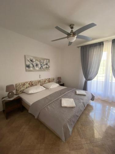 a bedroom with a large bed with a ceiling fan at Apartman "Niko" in Povile