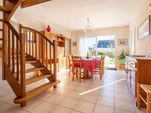 une cuisine et une salle à manger avec une table et un escalier dans l'établissement Maison spacieuse à Carnac - 8 pers, jardin clos, proche plage, Wifi, garage, petit animal accepté - FR-1-477-50, à Carnac