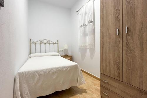 a bedroom with a bed and a wooden cabinet at Complejo Turístico Rural Nazaret De Moguer in Moguer
