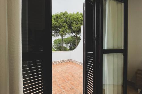 a door leading to a patio with a window at Complejo Turístico Rural Nazaret De Moguer in Moguer