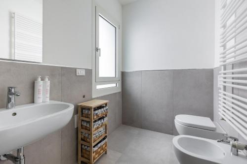 łazienka z umywalką, toaletą i oknem w obiekcie Casa Bassani con terrazzo by Wonderful Italy w Bolonii